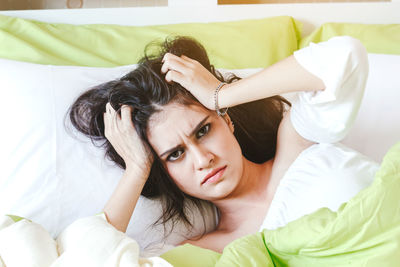 Portrait of irritated woman lying on bed