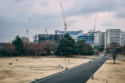 Construction site by buildings in city against sky