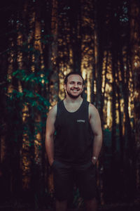 Portrait of young man standing in forest