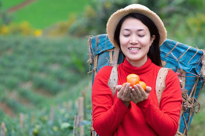 Young woman holding strawberry outdoors