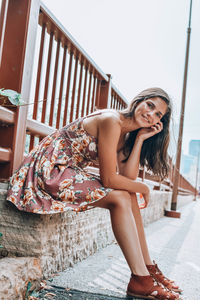 Portrait of young woman sitting outdoors