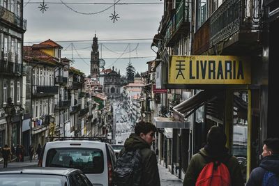 Road sign in city against sky