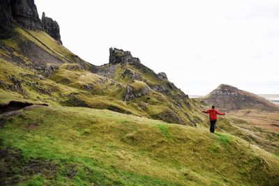 Rear view of man on mountain against sky