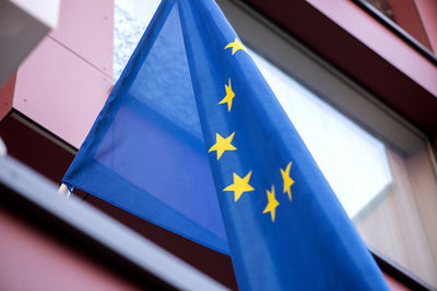 Close-up of flags against blue wall