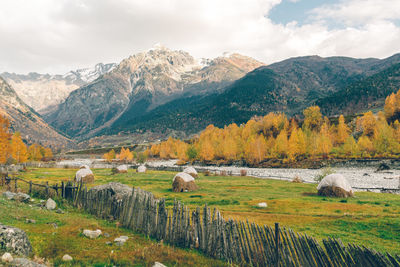 Scenic view of field with river and mountains against sky