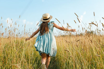 Full length of woman standing on field against sky