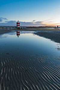 Scenic view of beach by sea against sky