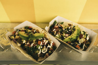 Pair of fresh tacos in take away boxes on concession stand