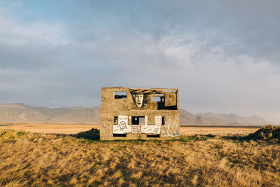 Abandoned house on field against sky