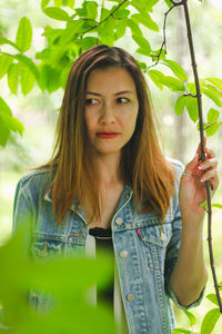 Beautiful woman standing by plant