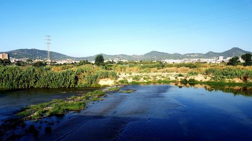 Scenic view of lake against clear blue sky