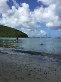 Scenic view of beach against cloudy sky