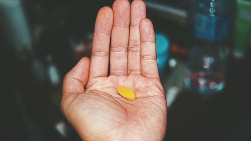 Cropped hand holding pill