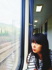 Woman looking through window in train