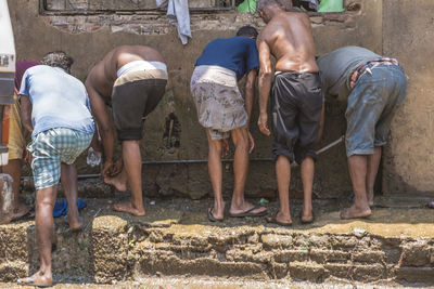 Rear view of people working in water