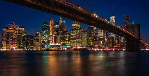 Illuminated buildings and brooklyn bridge at night