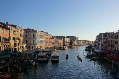 Boats in canal against clear sky