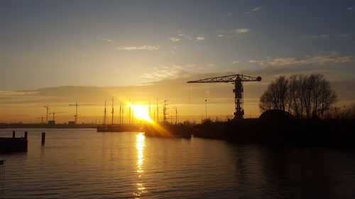 Silhouette of traditional windmill against sky during sunset