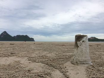 Scenic view of beach against cloudy sky