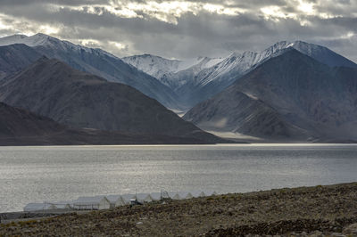 Scenic view of lake by mountains against sky