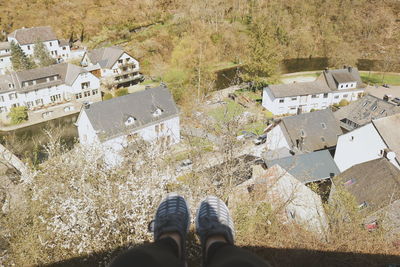 Low section of person sitting on the wall overlooking the town