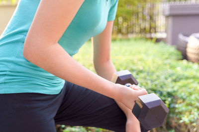 Midsection of woman exercising at park