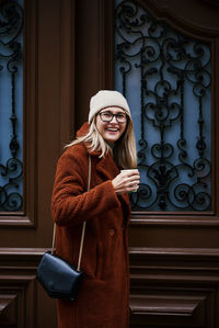 Woman with coffe near door