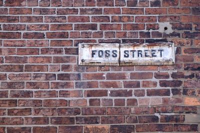 Close-up of text on brick wall
