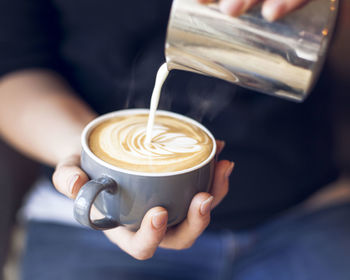 Close-up of barista holding coffee cup