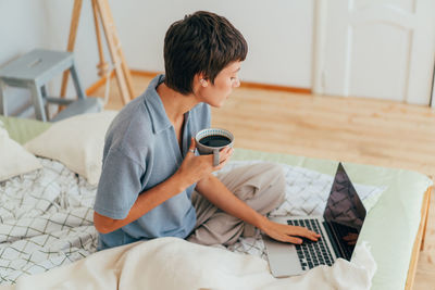 Young woman using laptop at home