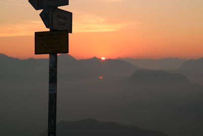 Information sign against sky during sunset