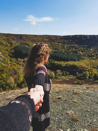 Cropped man holding hand of woman on field