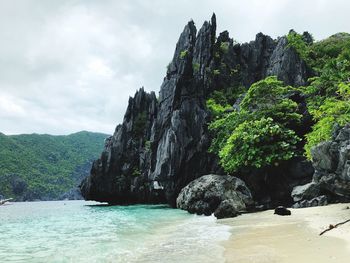 Rock formations by sea against sky