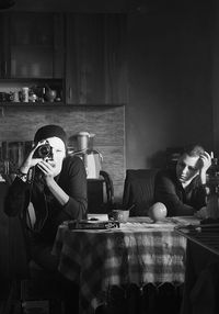 Young woman sitting on table at home