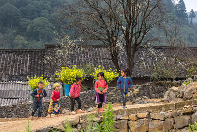 Rear view of people standing by tree