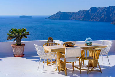 Chairs and tables in restaurant by sea