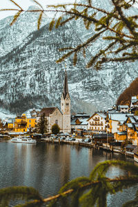 Buildings by river during winter