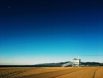 Scenic view of desert against clear blue sky