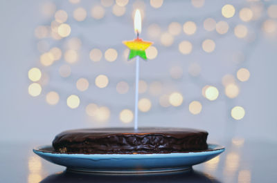 Festive birthday cake, burning candles against bright bokeh background. greeting card. party