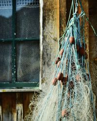 Close-up of fishing net hanging on metal fence