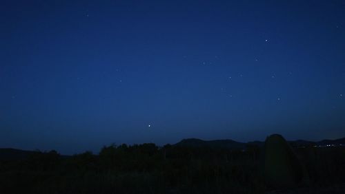 Scenic view of landscape against clear sky at night