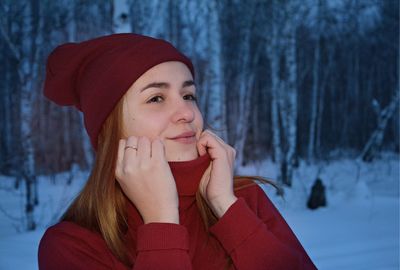 Portrait of young woman covered with snow during winter