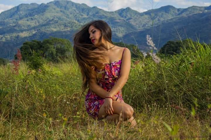 FULL LENGTH OF WOMAN STANDING ON GRASSY FIELD