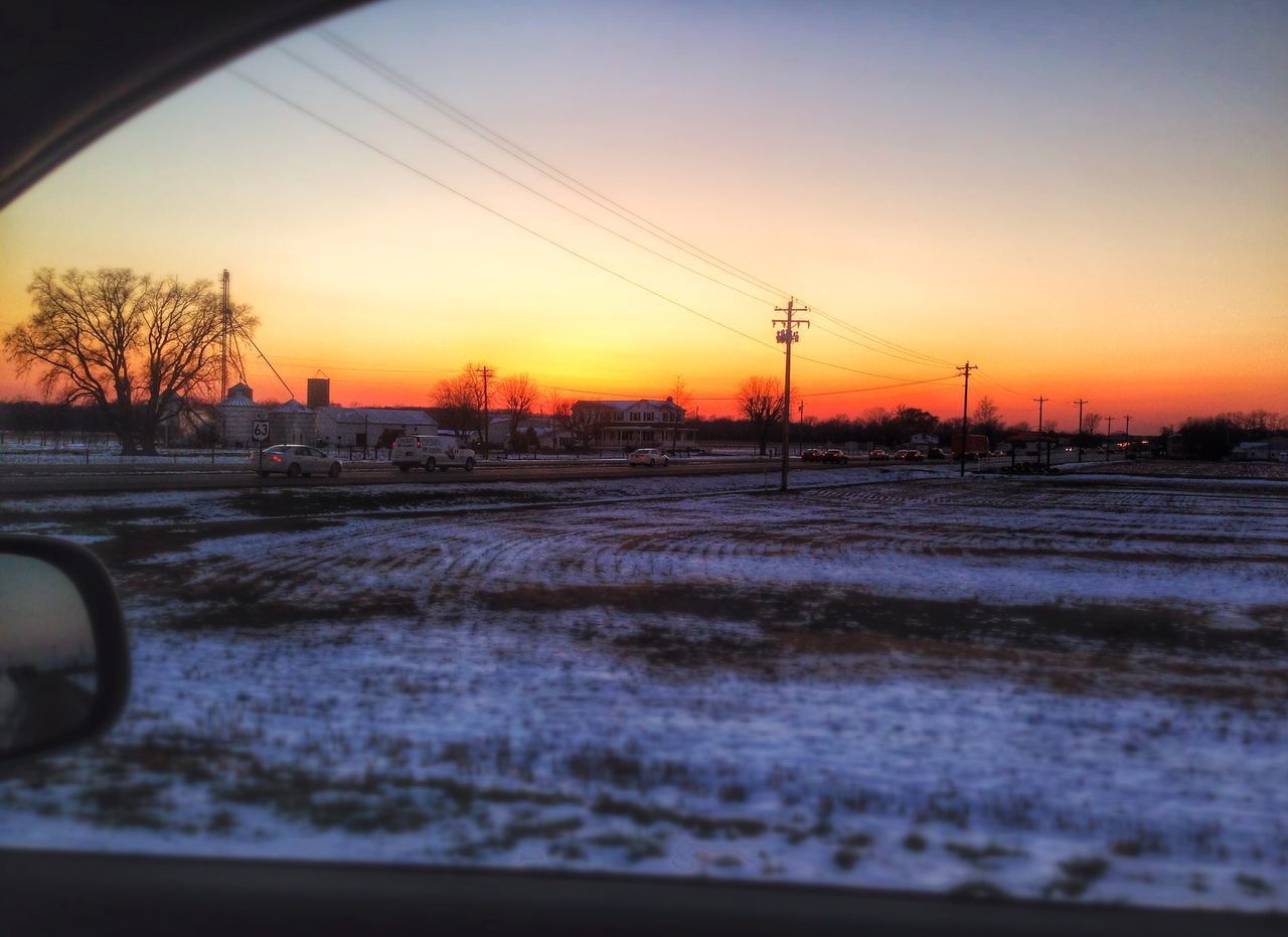 snow, winter, cold temperature, sunset, season, transportation, weather, landscape, clear sky, sky, field, road, nature, covering, frozen, orange color, electricity pylon, dusk, mode of transport, railroad track