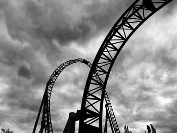 Low angle view of ferris wheel against cloudy sky