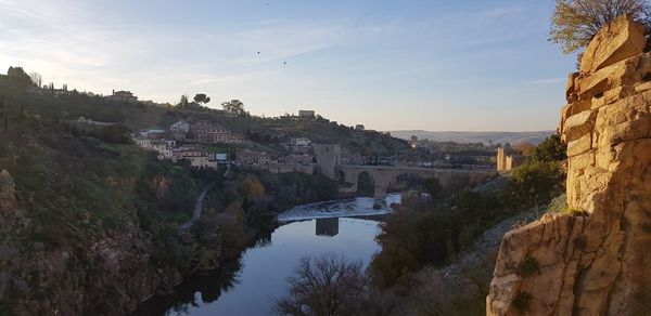 Scenic view of river amidst buildings against sky