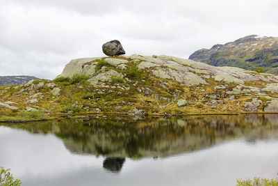 Scenic view of lake by mountain against sky