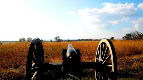 Cannon on grassy field against sky