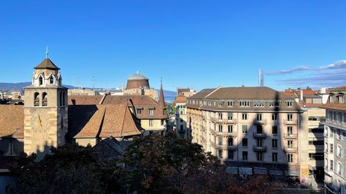 Buildings in city against clear blue sky