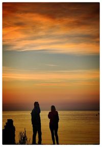 Rear view of silhouette people walking at sunset